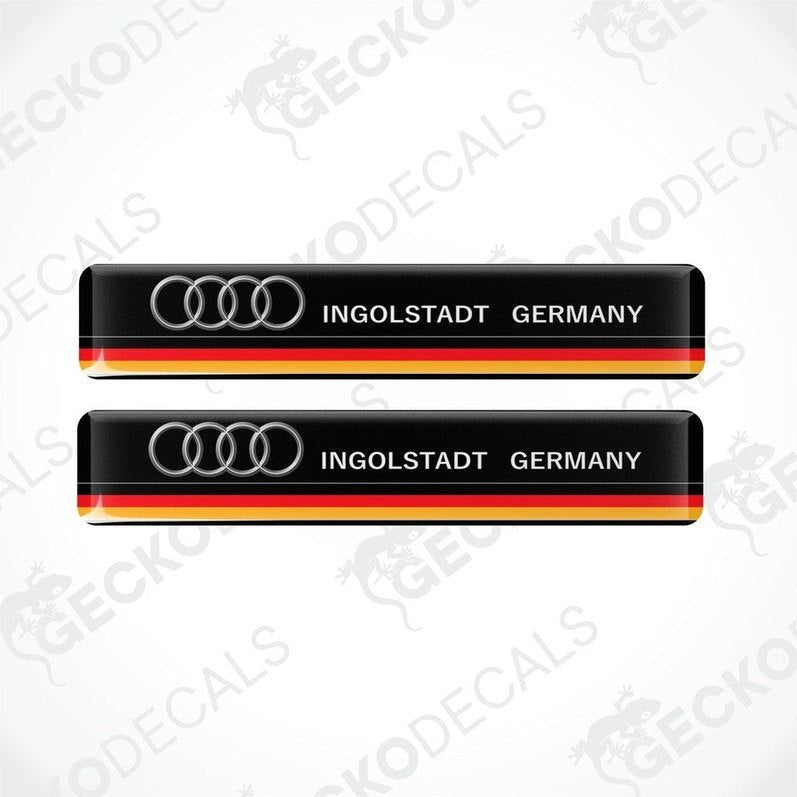 Two black vinyl stickers with red and yellow accents and the text 'INGOLSTADT GERMANY' along with the Audi brand logo.