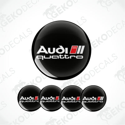 A set of black round car decals with the 'Audi quattro' logo in white and red.