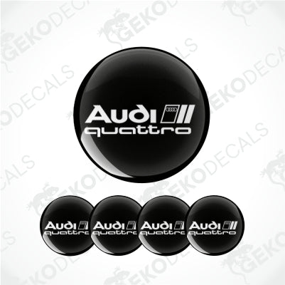 A set of four black vinyl stickers with the word 'Audi Quattro' printed on them.