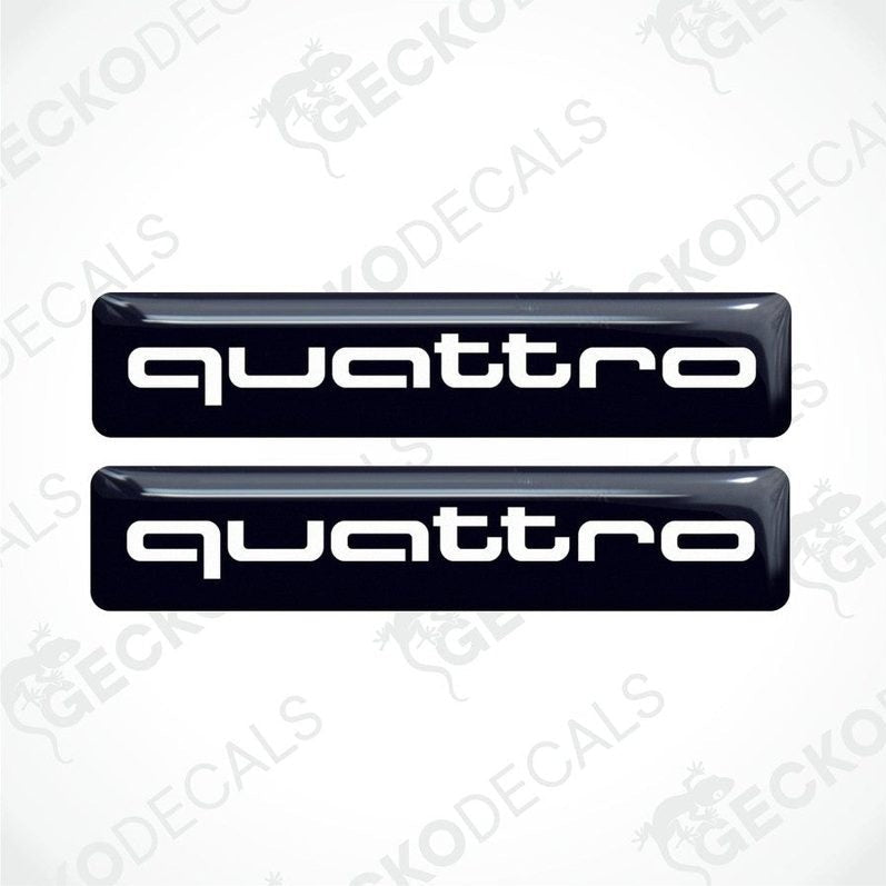 Two black vinyl stickers with the word 'QUATTRO' written in white, placed against a white background.