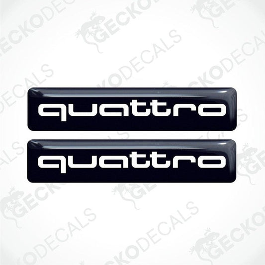 Two black vinyl stickers with the word 'QUATTRO' written in white, placed against a white background.
