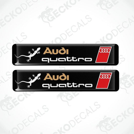 A set of two Audi Quattro branded vinyl decals with a black background and red and white accents.