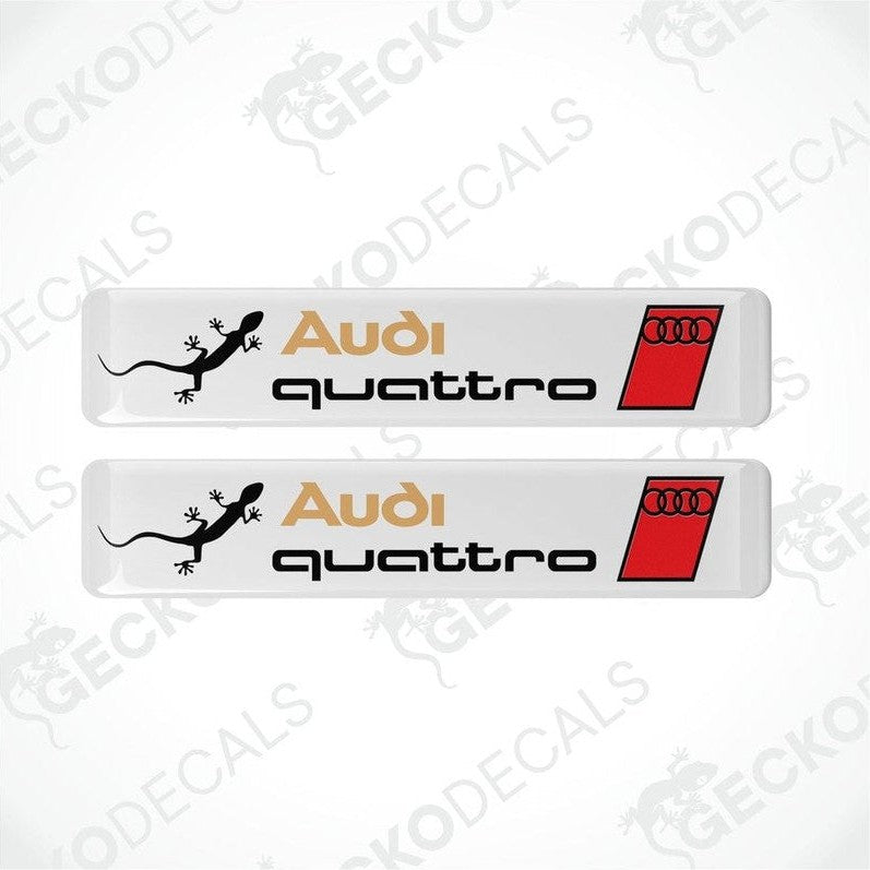 A set of two Audi Quattro branded vinyl decals with a white background and red and black accents.