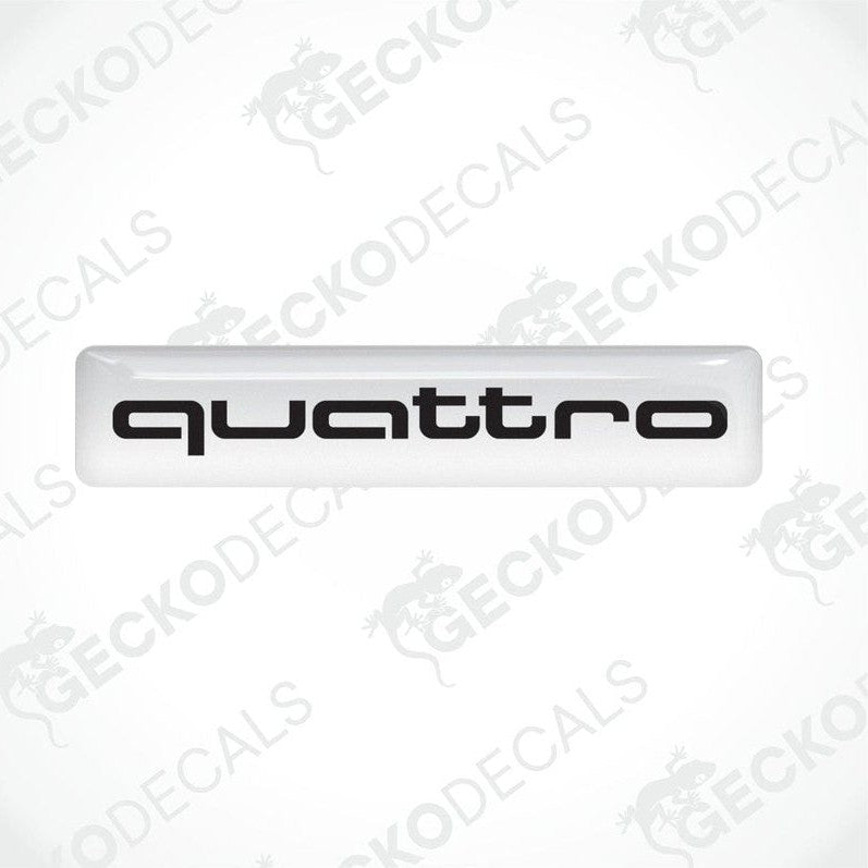 White vinyl stickers with the word 'QUATTRO' written in white, placed against a black background.