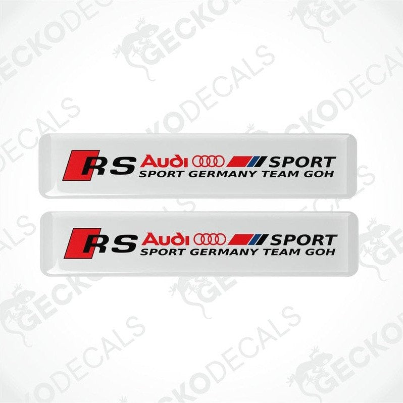 Two white rectangular car decals with red and black text and logos, representing Audi RS Sport Germany Team GOH.