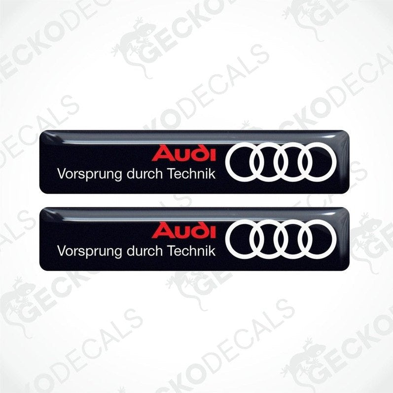 Two black vinyl decals with the Audi logo and the phrase 'Vorsprung durch Technik' in white lettering.