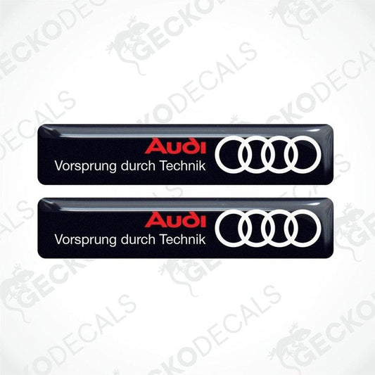 Two black vinyl decals with the Audi logo and the phrase 'Vorsprung durch Technik' in white lettering.