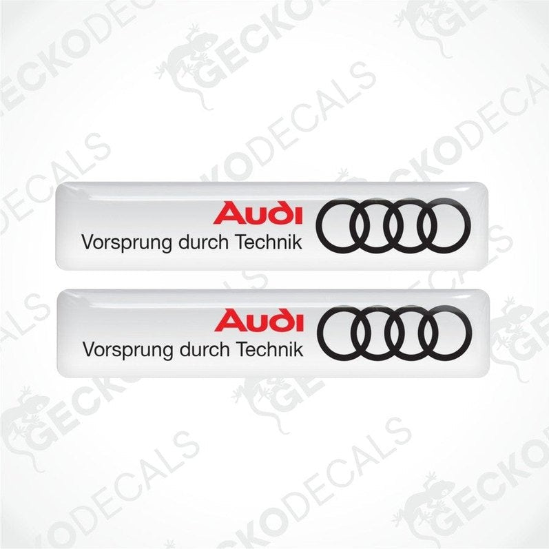 Two white vinyl decals with the Audi logo and the phrase 'Vorsprung durch Technik' in white lettering.