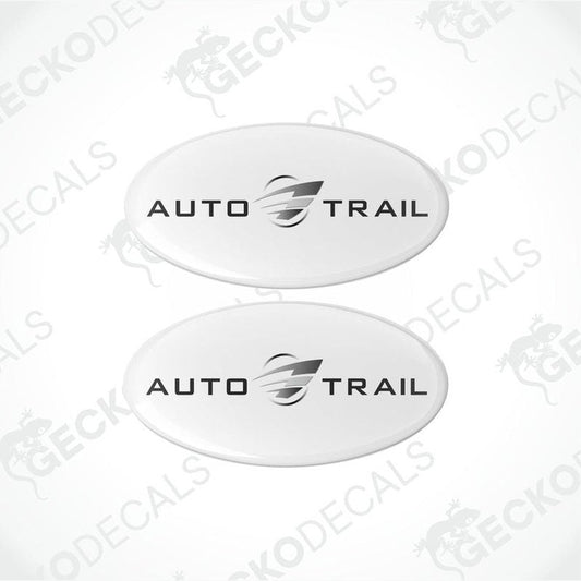Two white oval-shaped epoxy decals with the AUTO-TRAIL brand logo in black.
