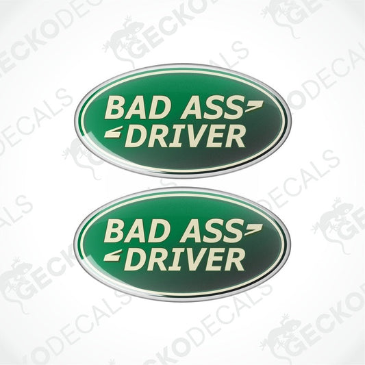Two green oval-shaped vinyl decals with the text 'BAD ASS DRIVER' in white and silver.

