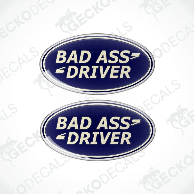 Two blue oval-shaped vinyl decals with the text 'BAD ASS DRIVER' in white and silver.

