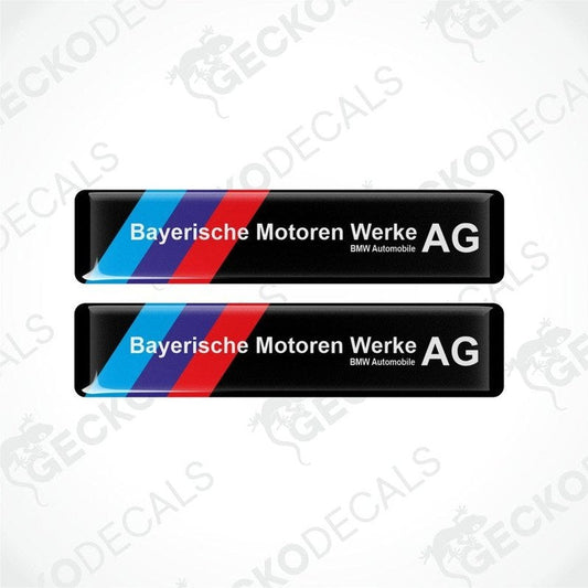 Two rectangular car decals with a striped pattern in blue and red on a white background, and white text saying 'Bayerische Motoren Werke AG BMW Automobile AG'.
