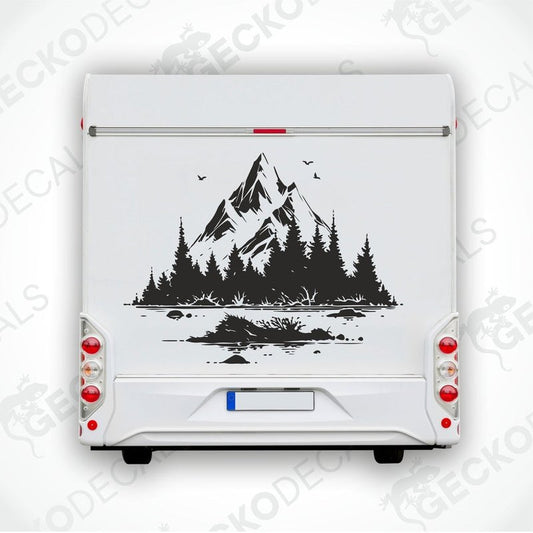A die cut decal of a mountain scenery with trees and birds, intended for use on vehicles or other surfaces, displayed on a white background.