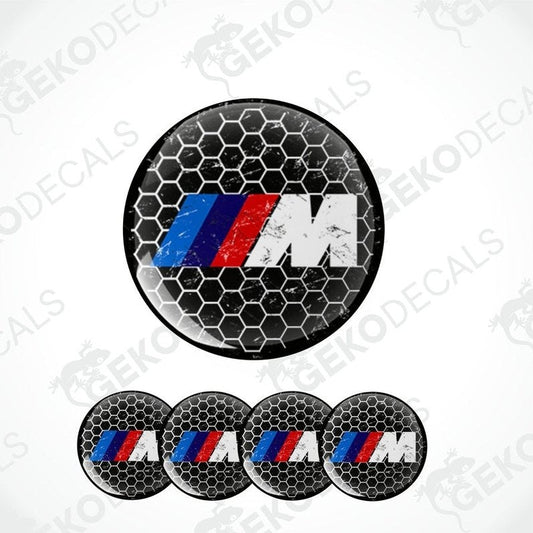 A set of four vinyl decals with polyurethane coating featuring the BMW M logo in black, red, and blue on a honeycomb pattern background.