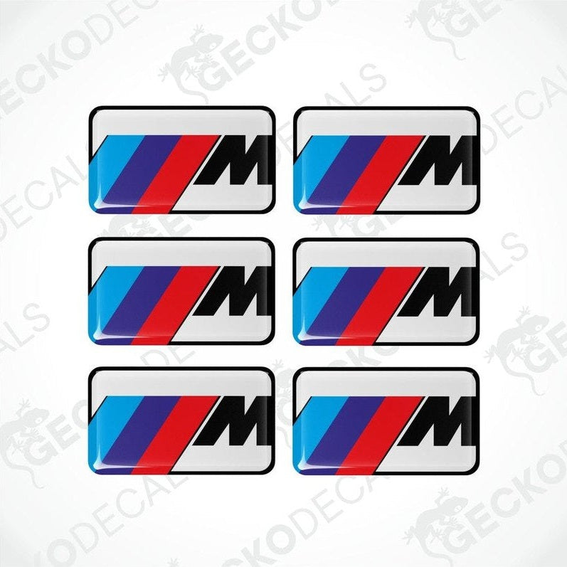Set of six white BMW M branded polyurethane-coated vinyl stickers on a white background.