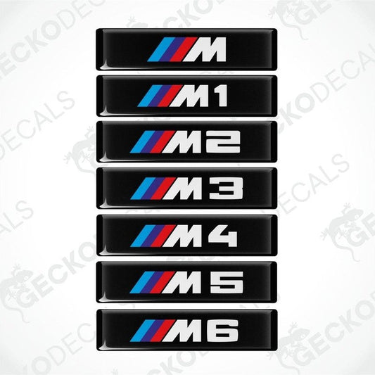 A series of black decals with white and colored text representing different BMW M series models from M1 to M6.