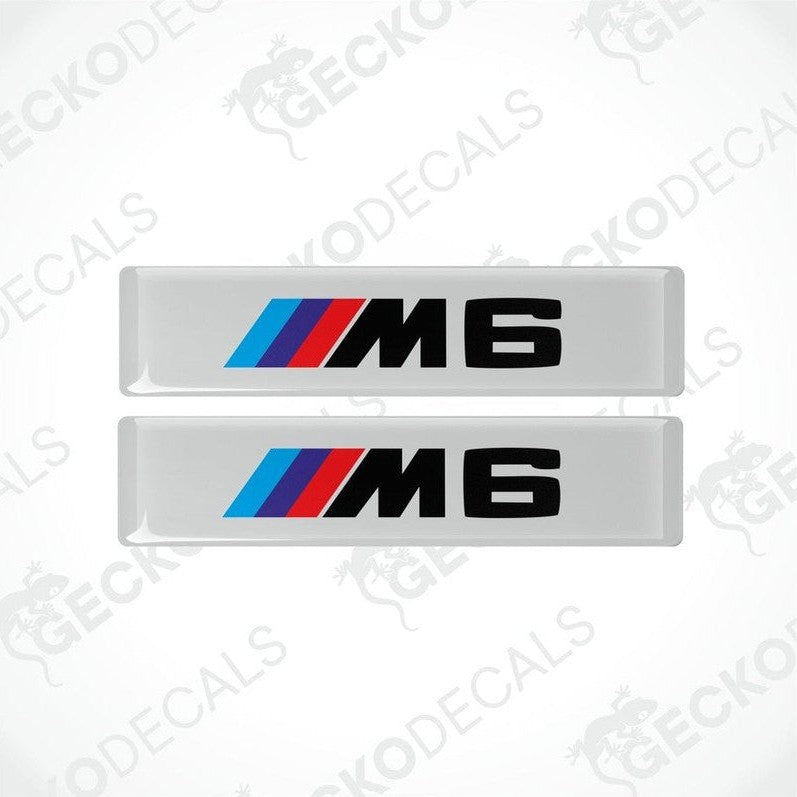 Two stickers with BMW M6 logos in light blue, blue and red on a white background