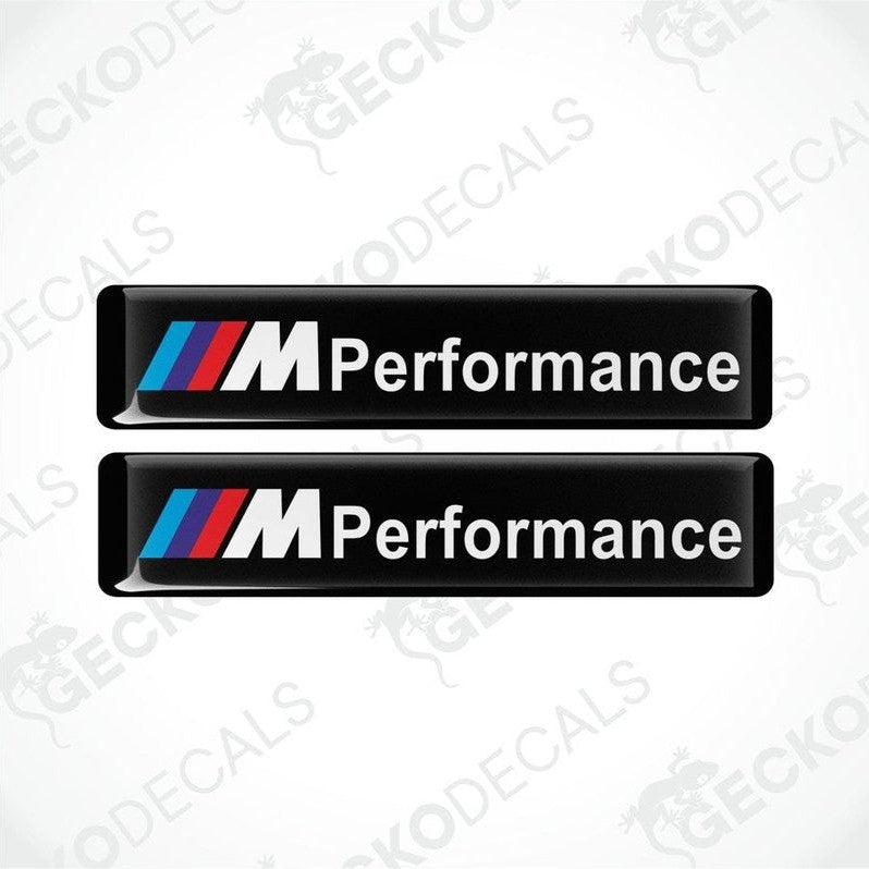 Two rectangular black vinyl decals with 'M Performance' text and the BMW logo in red, blue, and white.