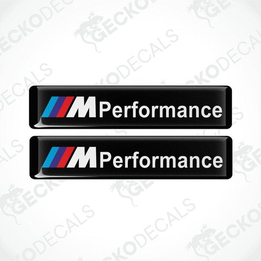 Two rectangular black vinyl decals with 'M Performance' text and the BMW logo in red, blue, and white.