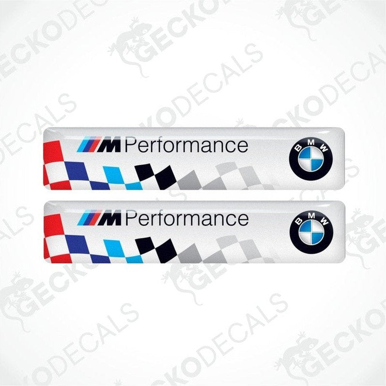 Two vinyl stickers with a BMW M PERFORMANCE logo, predominantly white with blue and red checkered pattern.