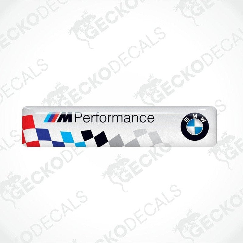 Vinyl stickers with a BMW M PERFORMANCE logo, predominantly white with blue and red checkered pattern.