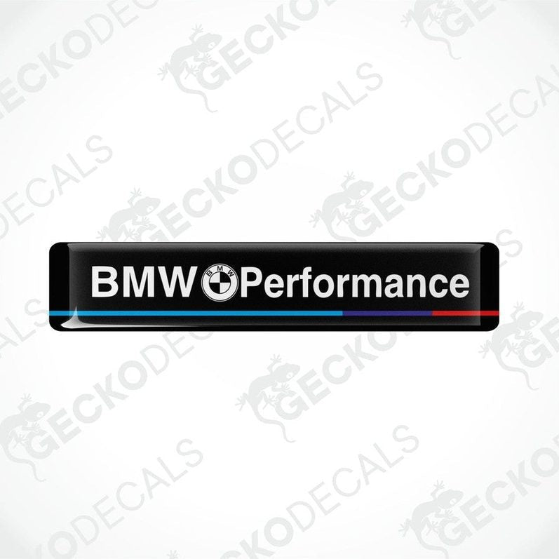Rectangular black vinyl decals with 'BMW Performance' text, one with a red stripe and one with a blue stripe.