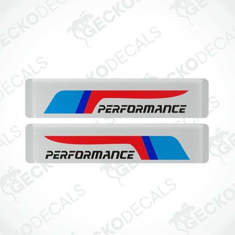 Two white vinyl stickers with red and blue geometric patterns and the text 'PERFORMANCE' on a black background.