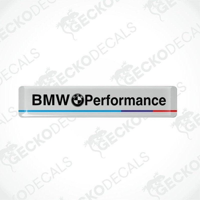  Rectangular white vinyl decals with 'BMW Performance' text, one with a red stripe and one with a blue stripe.