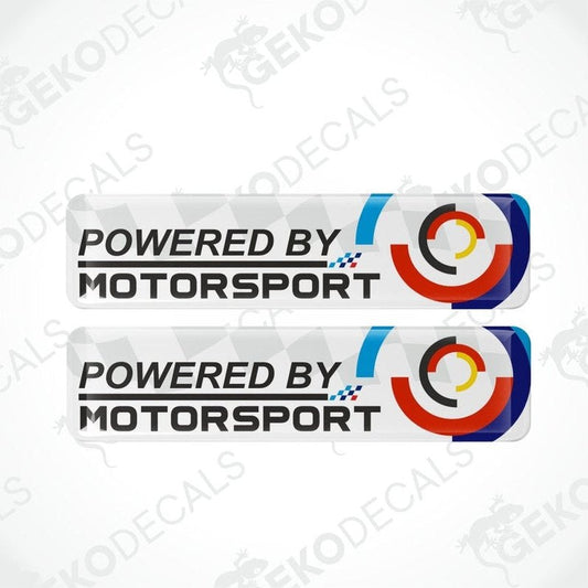 Two 'Powered by Motorsport' decals with a geometric design on a white background.