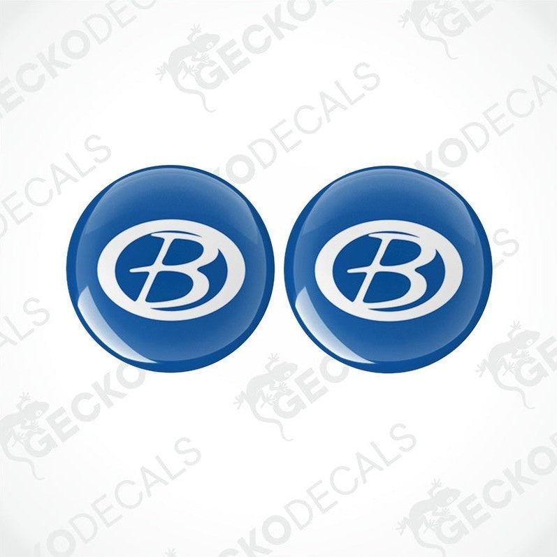 Two blue vinyl decals with a white 'B' logo, dome-shaped with a glossy finish.