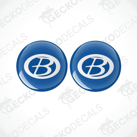 Two blue vinyl decals with a white 'B' logo, dome-shaped with a glossy finish.