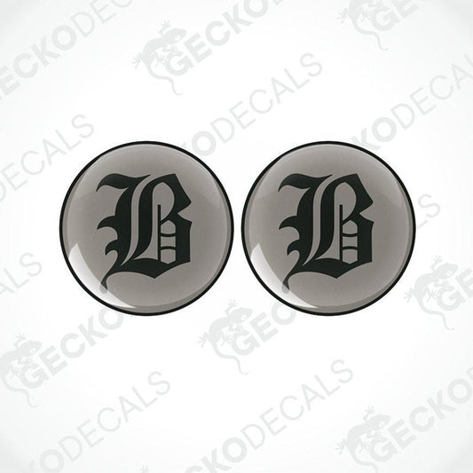 Two round black vinyl stickers with a large white 'B' in the center, placed against a white background with the text 'GECKODECALS'.