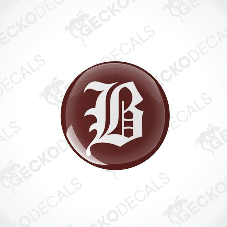 Single domed Buccaneer epoxy decal featuring ornate gothic B on brown