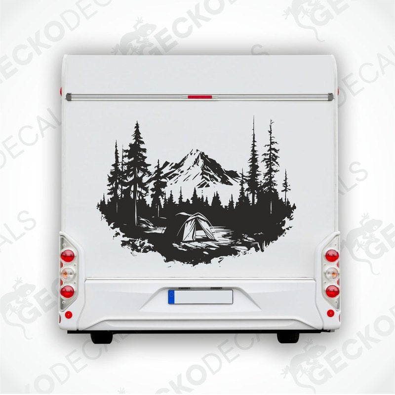 A black and white die cut decal of a mountain camping scene with trees and a cabin.