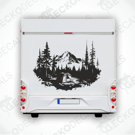 A black and white die cut decal of a mountain camping scene with trees and a cabin.