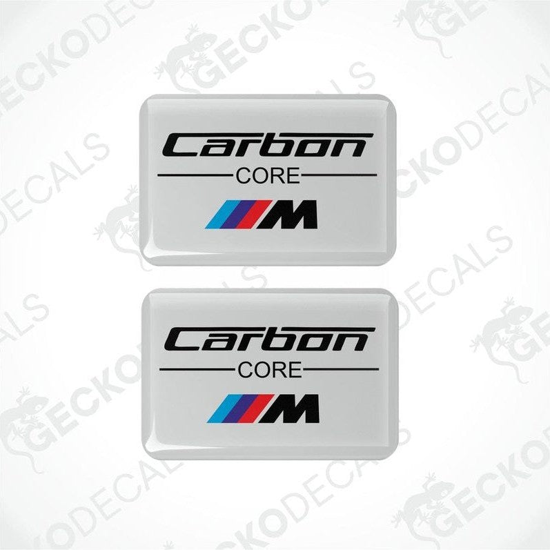 Two white vinyl stickers with the text 'CARBON CORE' and a BMW 'M' logo on a white background.