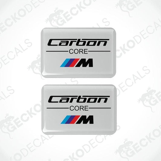 Two white vinyl stickers with the text 'CARBON CORE' and a BMW 'M' logo on a white background.