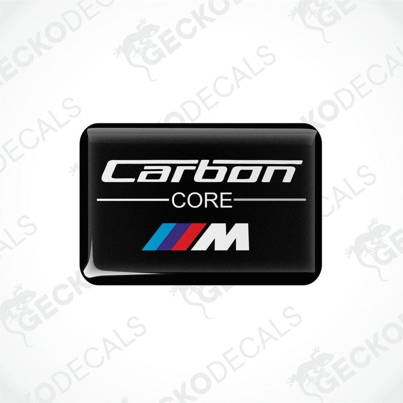 Rectangular black car decals with the words 'Carbon Core' and the BMW 'M' logo in white and red.
