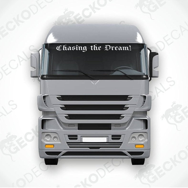 A decal with the phrase 'Chasing the Dream!' displayed on the front windscreen of a gray truck.