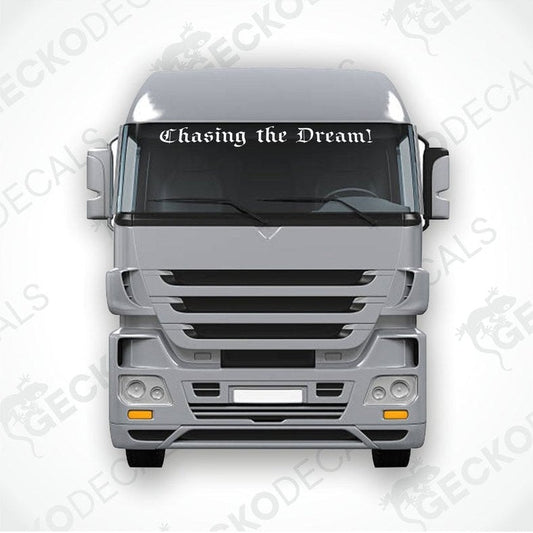 A decal with the phrase 'Chasing the Dream!' displayed on the front windscreen of a gray truck.