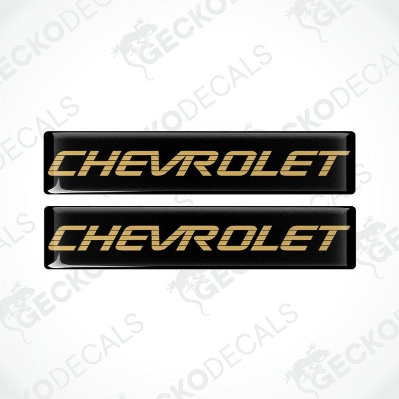 Two black vinyl stickers with the word 'CHEVROLET' in gold lettering, placed against a white background.