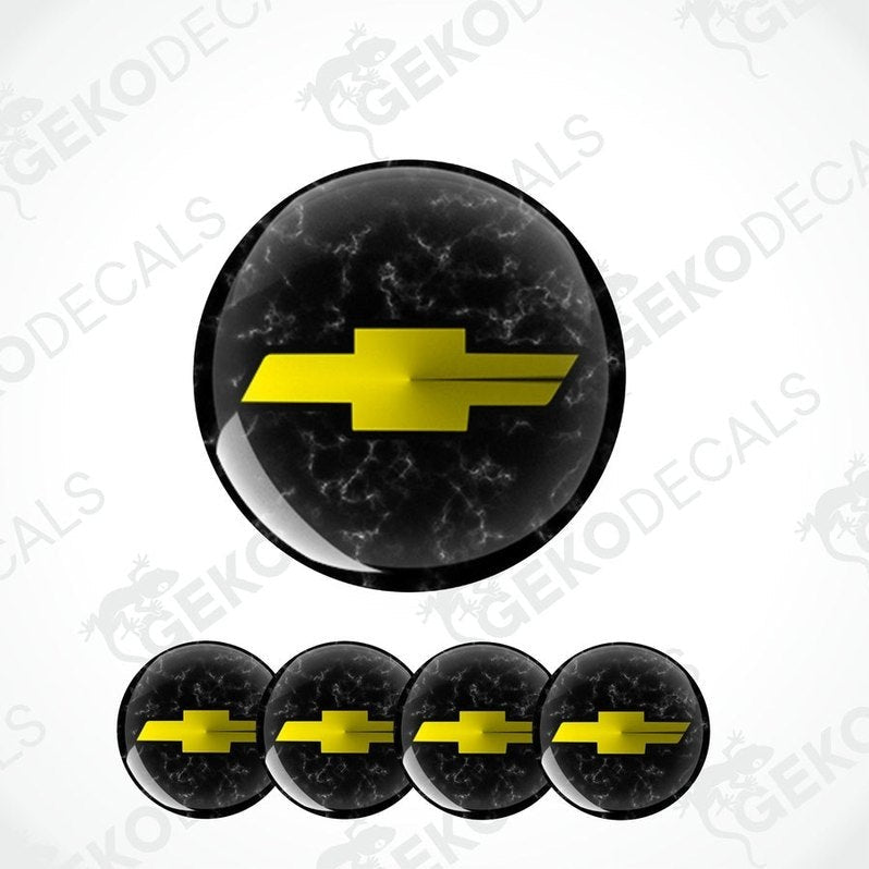 A set of four black vinyl stickers with a yellow chevrolet logo, designed for use on car wheels or caps.