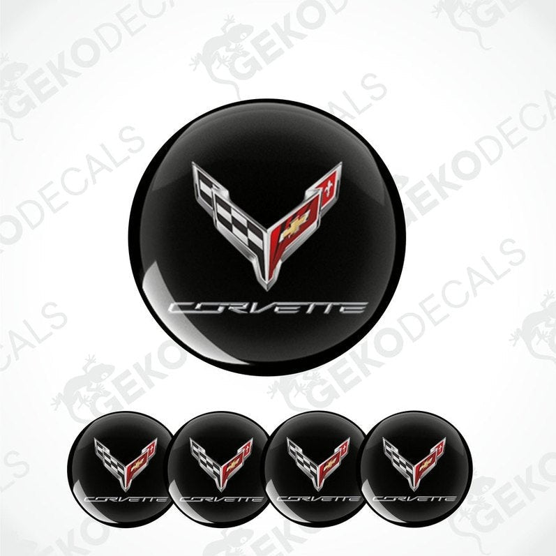 A set of four black vinyl stickers with the Chevrolet Corvette logo, including a design with red and white accents.