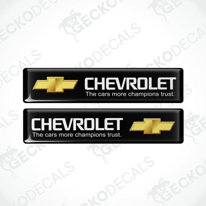 Two black vinyl stickers with the Chevrolet logo in white and a slogan 'THE CARS MORE CHAMPIONS TRUST'.
