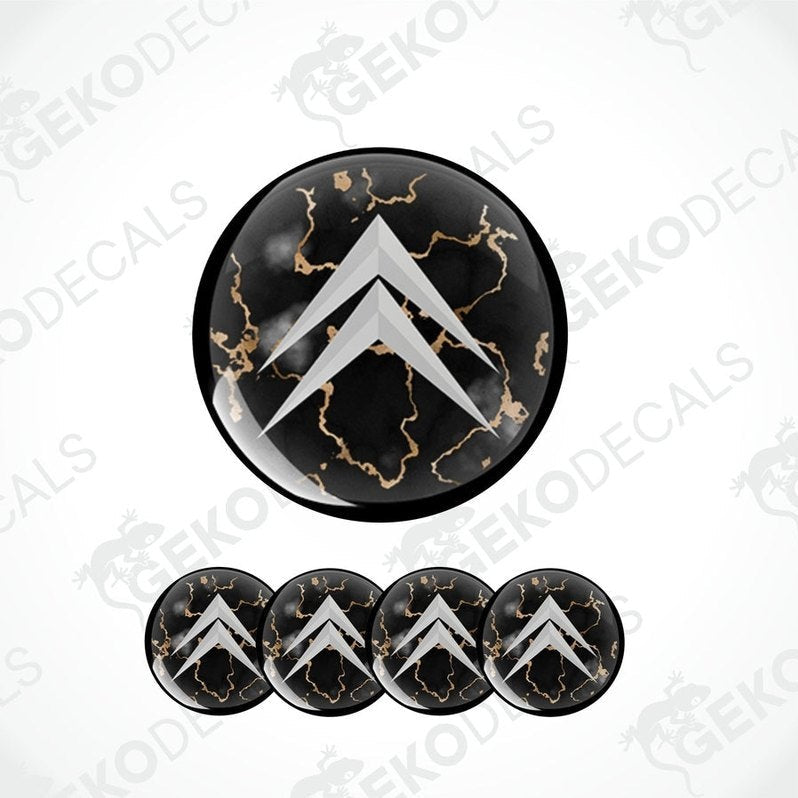 A set of four black vinyl stickers with a gold-colored design, arranged on a white background. Each sticker has a domed shape with a distinctive pattern and the brand 'CITROEN' marked on the top.