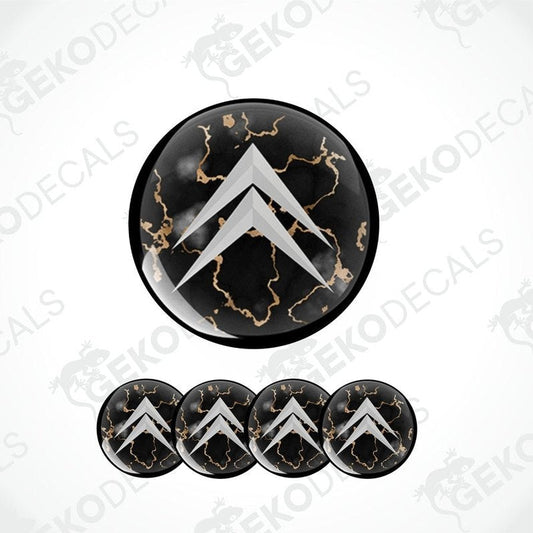 A set of four black vinyl stickers with a gold-colored design, arranged on a white background. Each sticker has a domed shape with a distinctive pattern and the brand 'CITROEN' marked on the top.