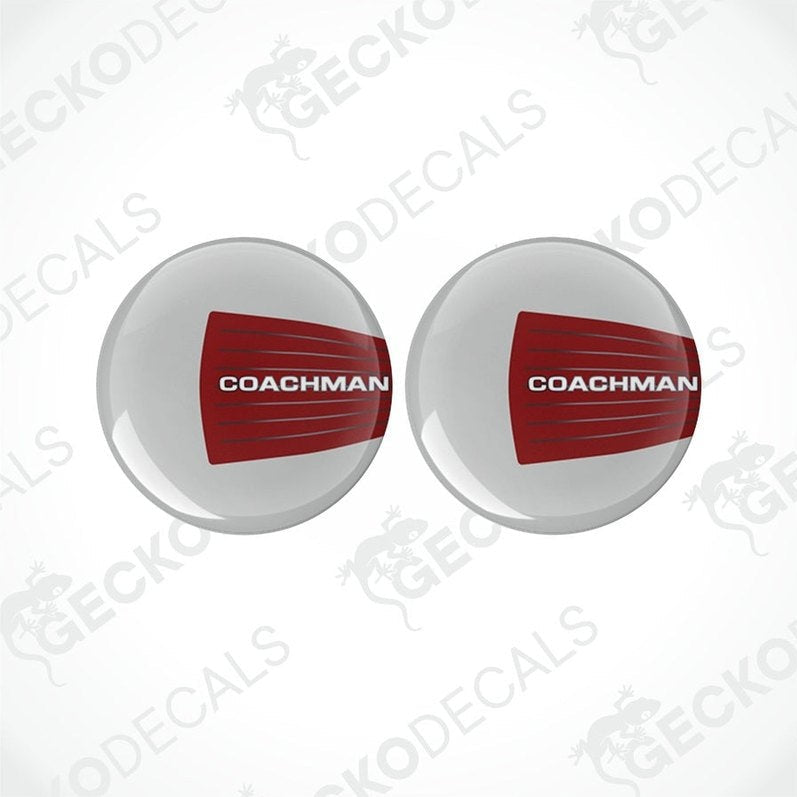 Two round white vinyl decals with the red text 'COACHMAN' on them, placed on a white background.