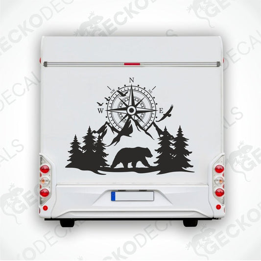 A black decal of a compass with bear and trees on the side of a white vehicle.