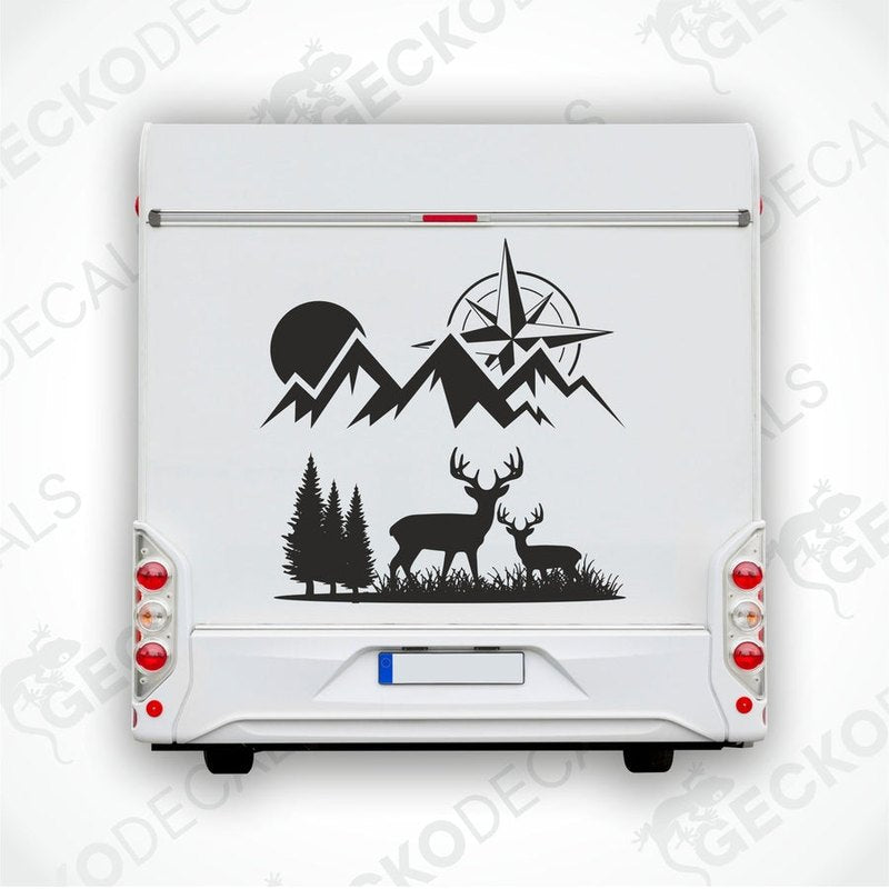 A black and white decal of a compass with mountains and deer on the front of a white vehicle.