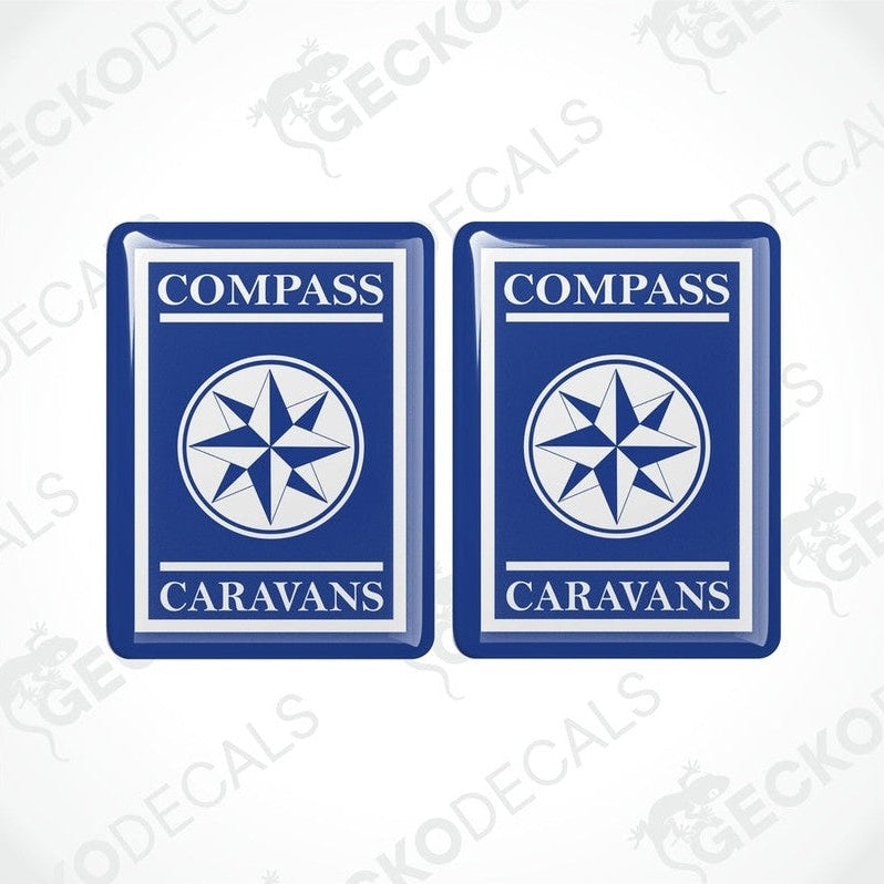 Two blue vinyl decals with a white compass design and the text 'COMPASS CARAVANS' on them.